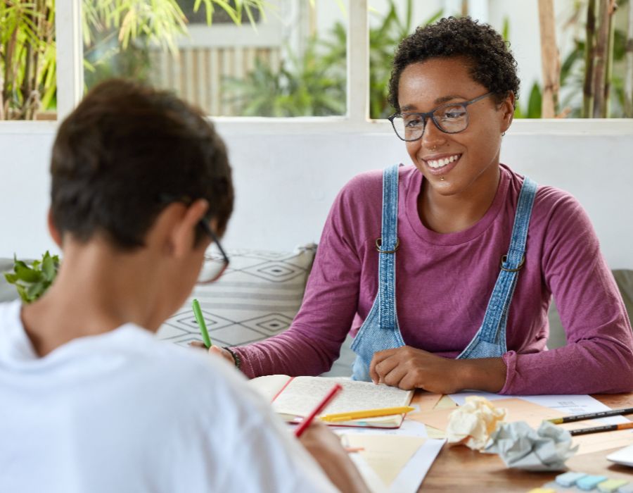 Two people studying together, smiling.
